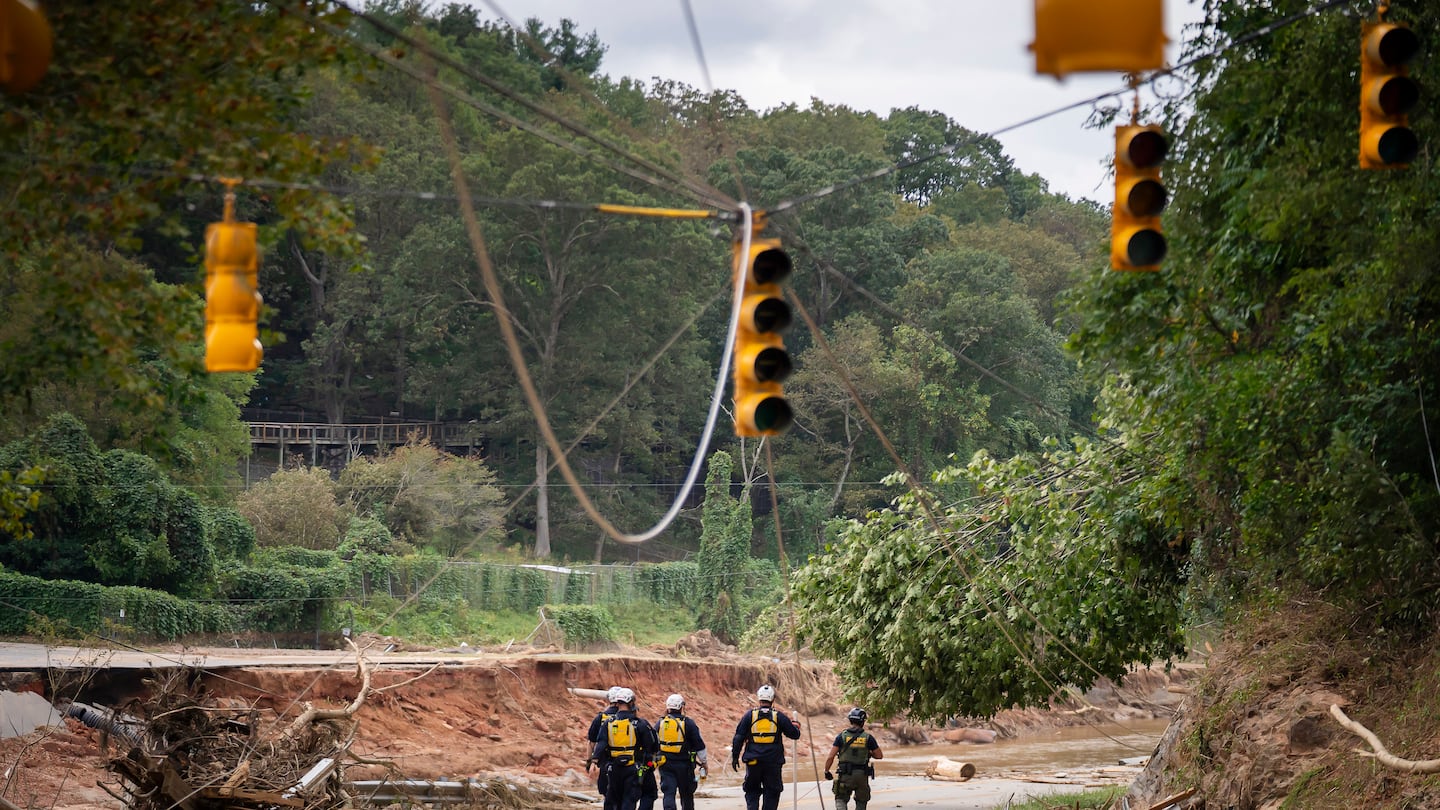 A search and rescue crew walked along what had been a road in Asheville, N.C., on Monday.