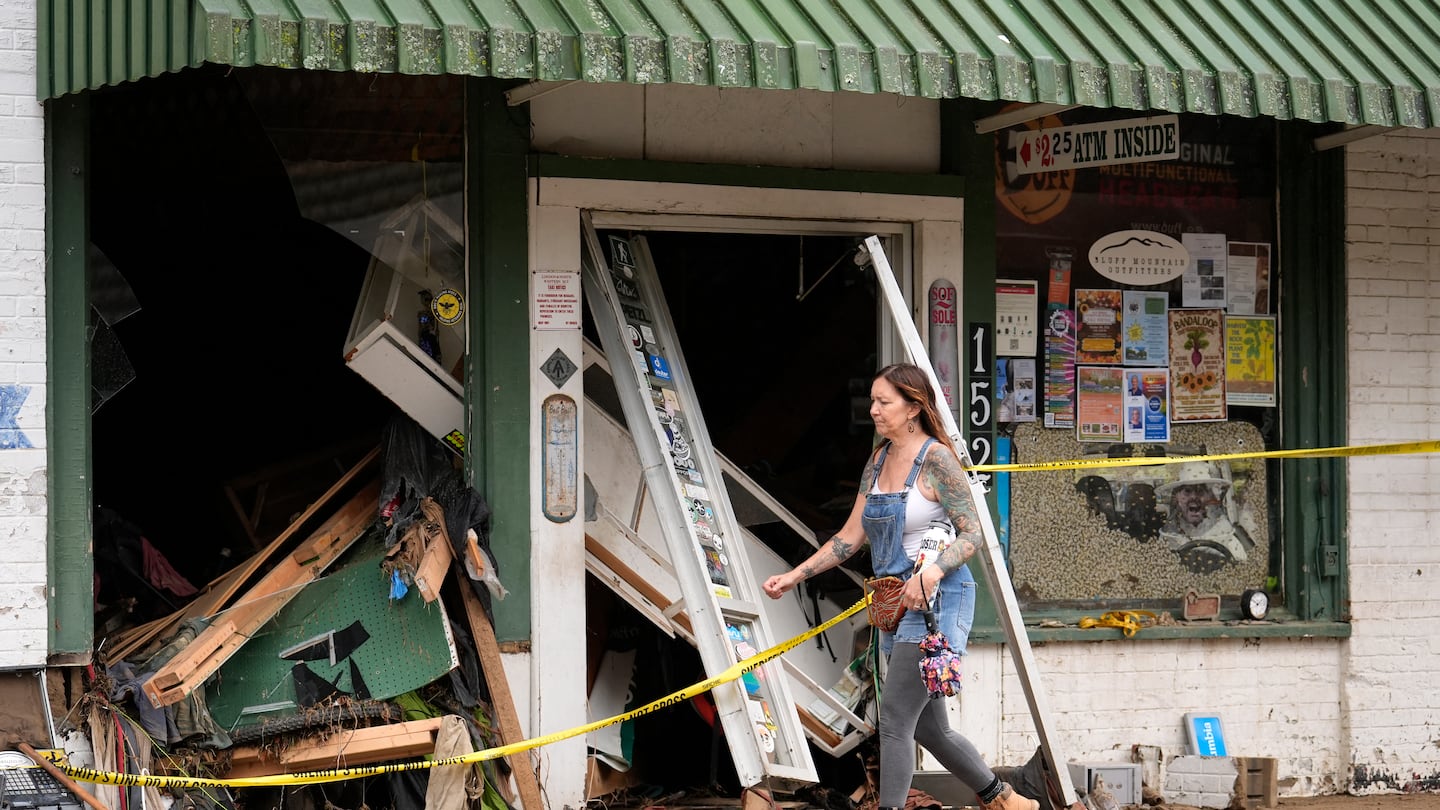 A person walks past a building heavily damaged during Hurricane Helene, Oct. 1, in Hot Springs, N.C.