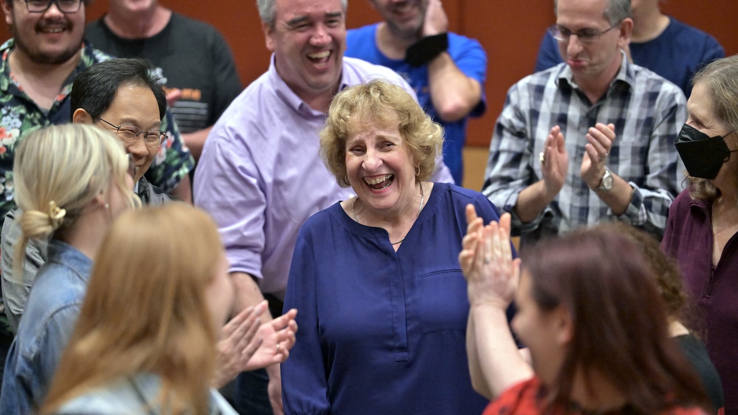 Irene Gilbride, center, reacts as fellow members of the Tanglewood Festival Chorus applaud after singing Happy Birthday to her during a rehearsal for Mahler's Symphony No. 8 in a space at New England Conservatory. This weekend's performances will mark the retirements of a few chorus members, including Gilbride.