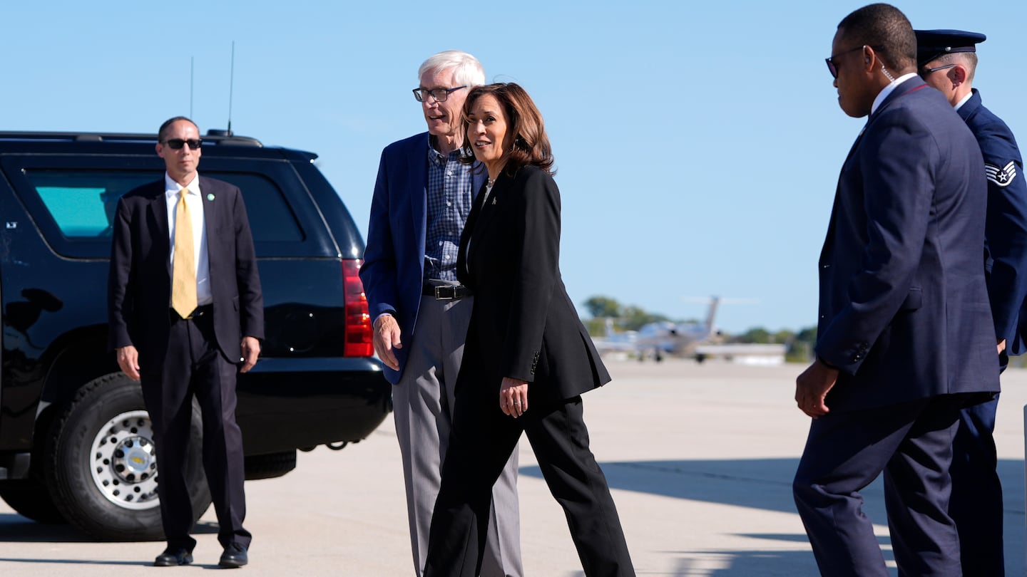 Vice President Kamala Harris walks with Wisconsin Governor Tony Evers as she arrives at Wittman Regional Airport in Oshkosh, Wis., Thursday, Oct. 3, 2024.