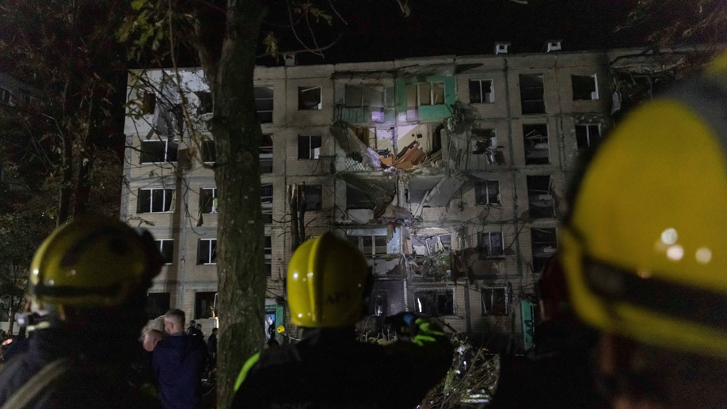 Firefighters work on a site of a building damaged by a Russian airstrike in Kharkiv, Ukraine, on Oct. 3.