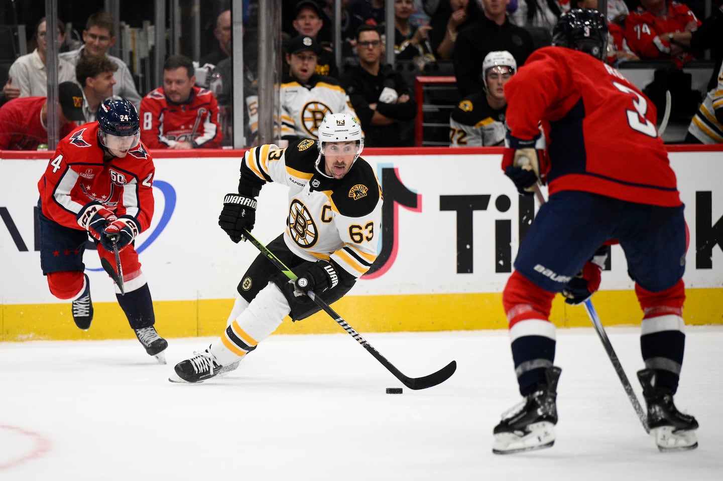 Bruins captain Brad Marchand carried the puck between the Capitals' Connor McMichael (left) and Matt Roy in the preseason finale.