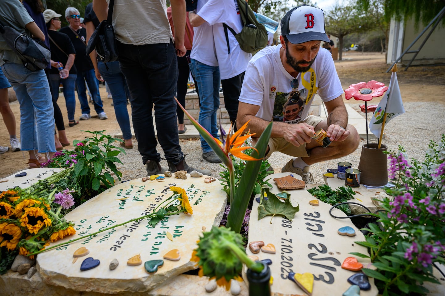 Daniel Lifschitz right,, grandson of hostage Oded Lifschitz, lit a memorial candle at the grave for his best friend Dolev Yehud who was thought to be a hostage but was later killed on the 7th and his body was taken to Gaza, on the first anniversary since Hamas attacked one year ago on Oct. 7, 2024, in Nir Oz, Israel.