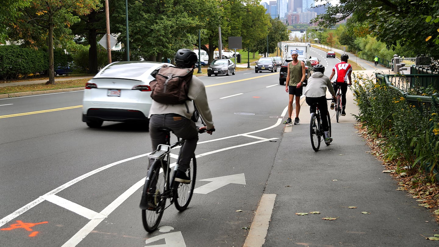 Cyclists on Memorial Drive eastbound near the BU bridge, where the designated bike lane ends at a sidewalk.