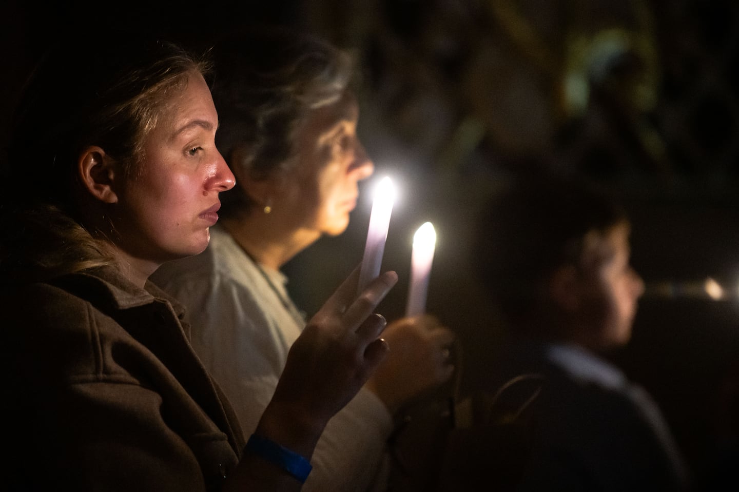 Attendees at Harvard held candles during a vigil on Monday.