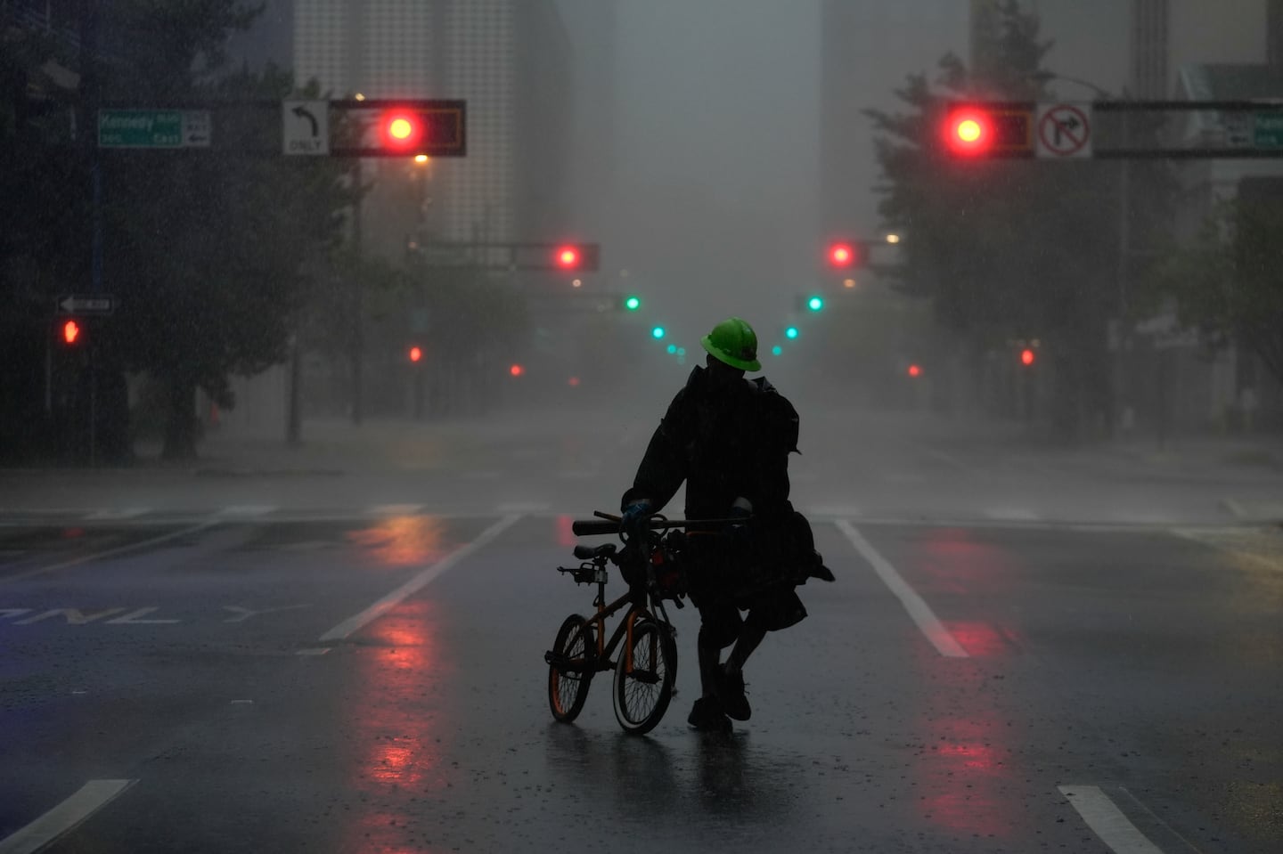 Ron Rook, who said he was looking for people in need of help or debris to clear, walked through windy and rainy conditions on a deserted street in downtown Tampa, Fla., during the approach of Hurricane Milton, Wednesday.