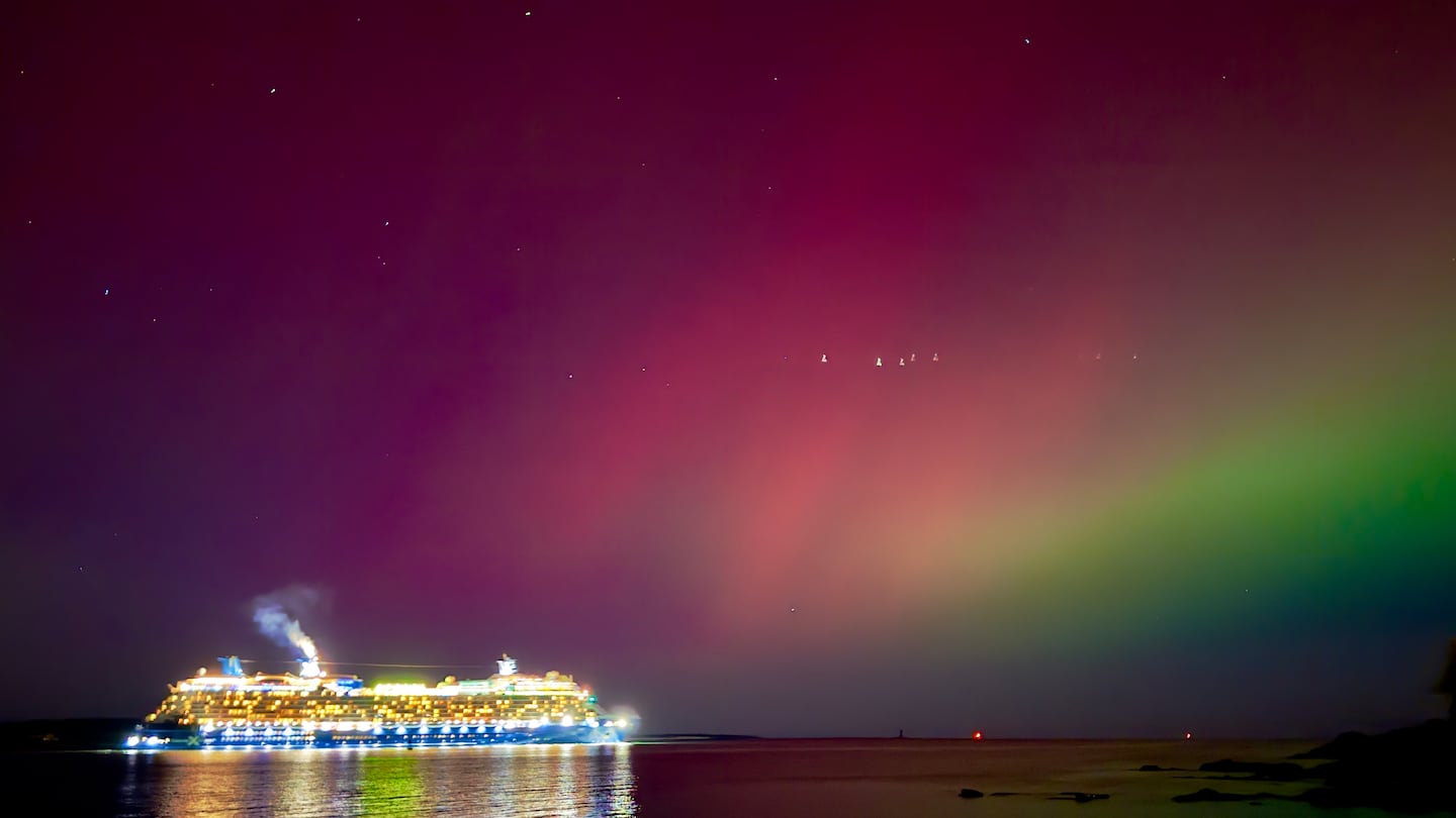 The aurora borealis shines over a cruise ship passing through Portland, Maine.