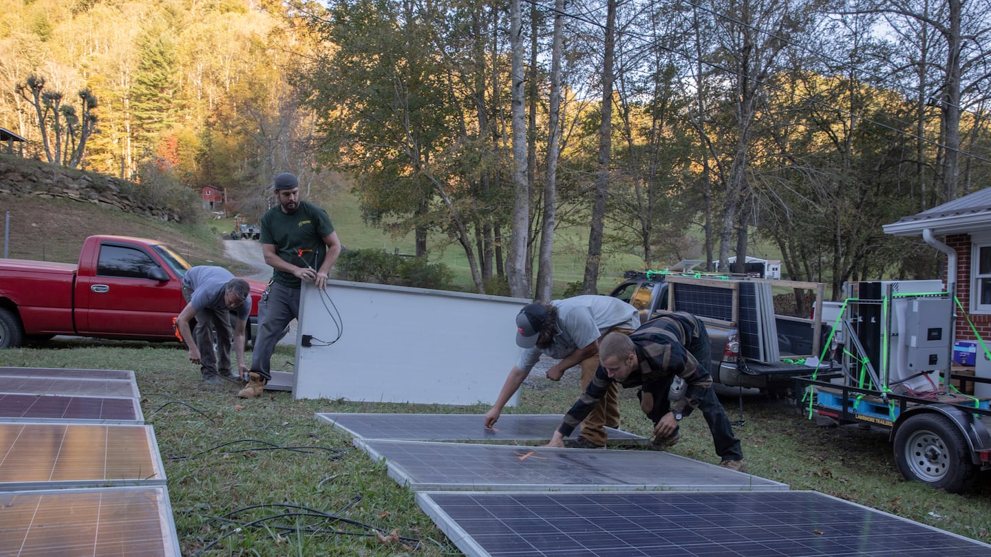 Hayden Wilson, left, Alexander Pellersels, second from left, Jonathan Bowen and Henry Kovacs, right, install a mobile power system at the Beans Creek Church of the Lord Jesus Christ in Bakersville, N.C., on Oct. 9.