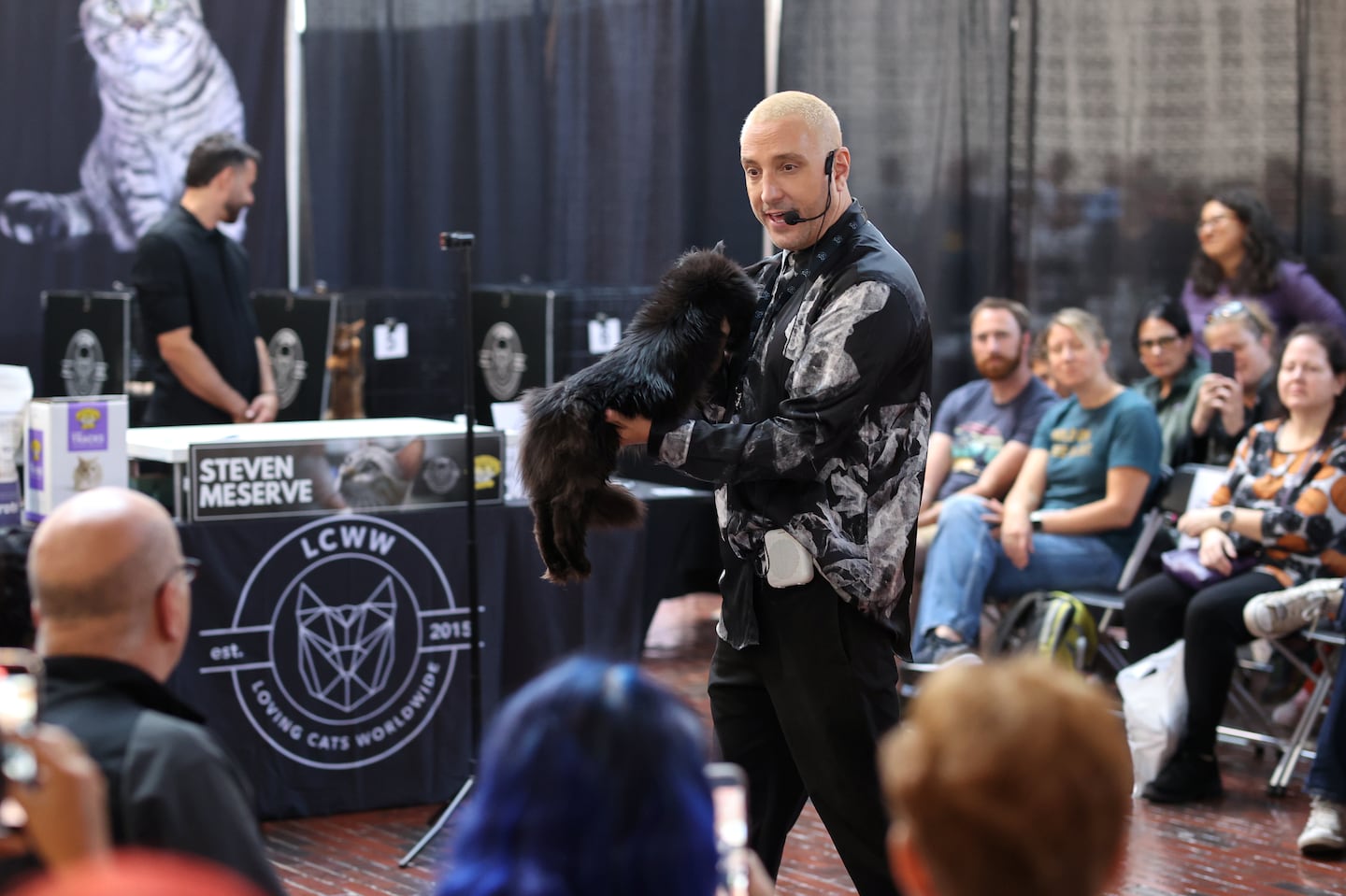 Steven Meserve held a cat at the Boston CATstravaganza, hosted by Loving Cats Worldwide.