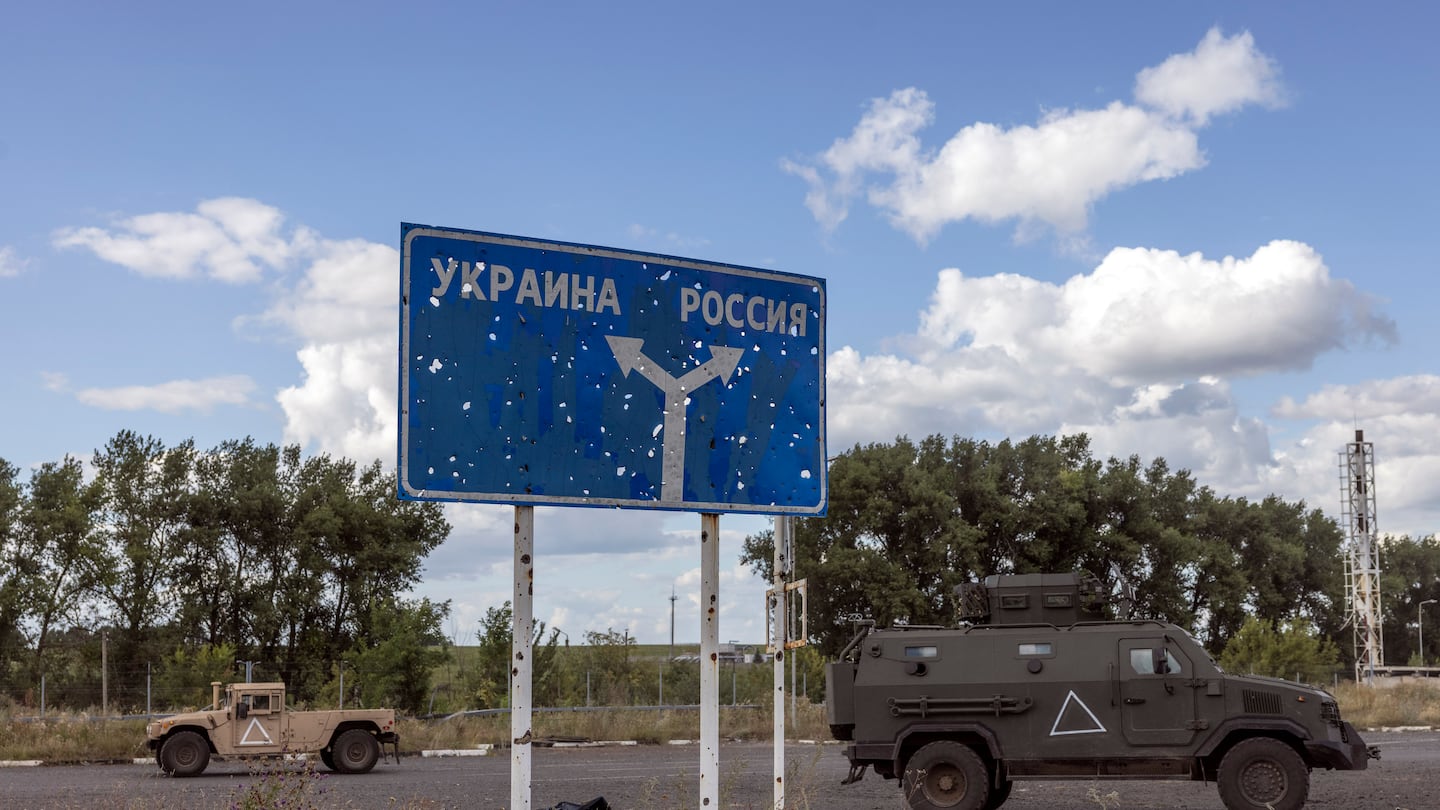 Ukrainian army vehicles passed by a sign that read “Ukraine” (left) and “Russia” (right) on a Russian road near a destroyed border post in August. Moscow’s forces have recaptured some villages and land taken in a Ukrainian incursion into Russia.