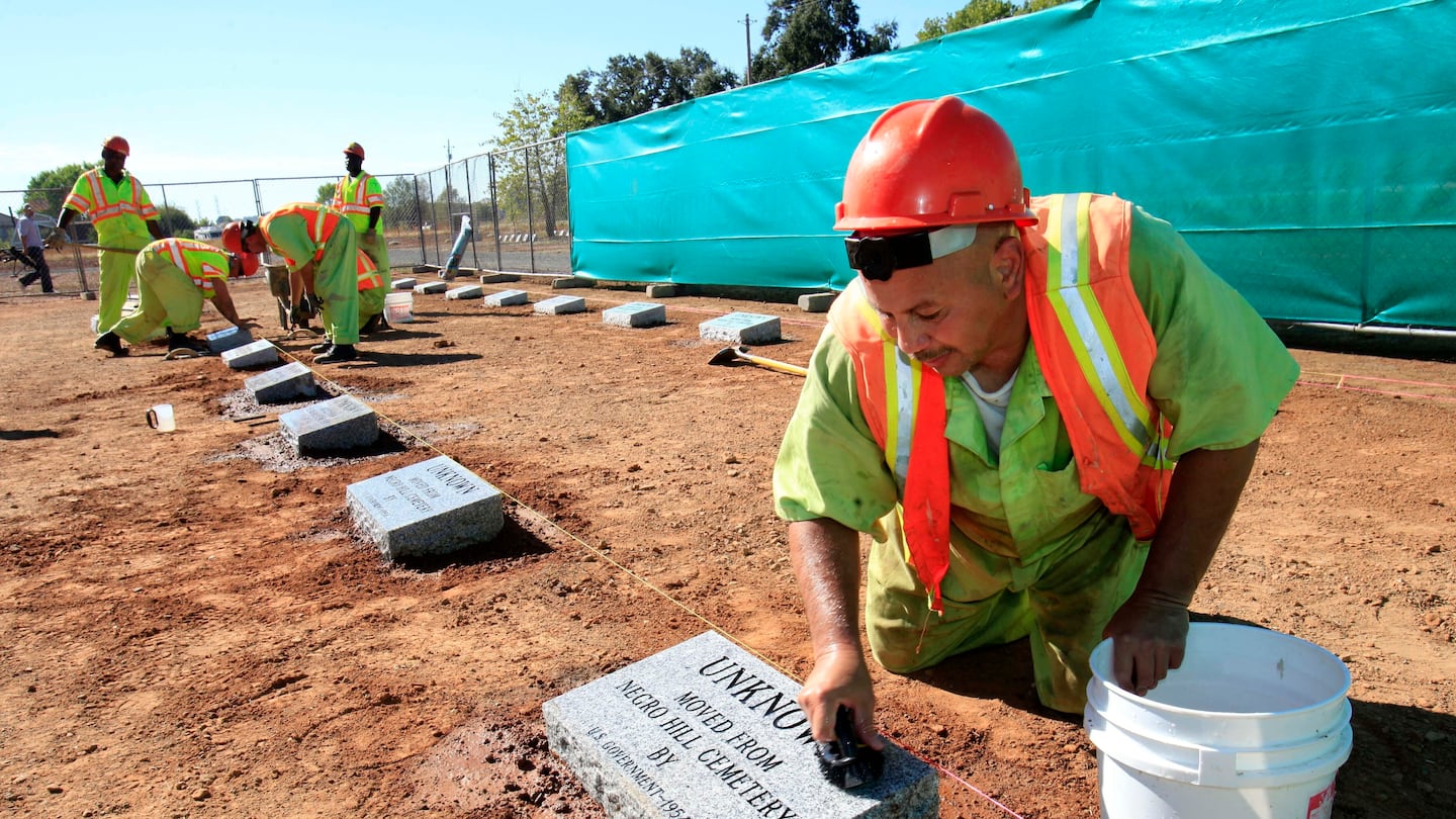 Steven Abujen, a California prison inmate with the Prison Industry Authority, cleans one of the newly installed headstones at the Mormon Island Relocation Cemetery, near Folsom, Calif., on Oct. 18, 2011.