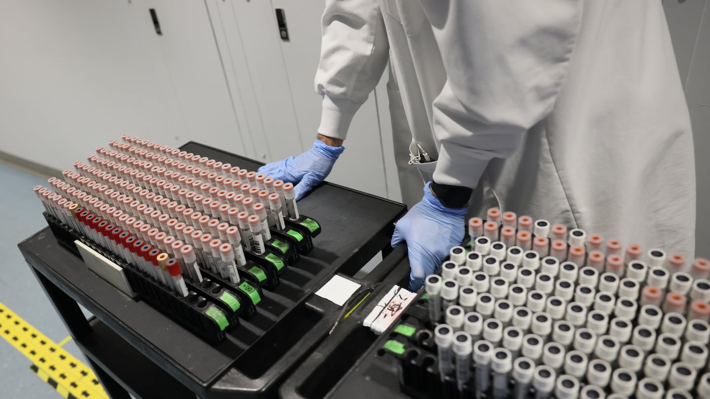 A Broad Institute employee wheeled a cart full of COVID-19 tests for processing at the Broad Institute in December 2021. At the time, the Broad Institute processed thousands of COVID-19 tests a day and then scrutinized as many as 5,000 per week for signs of worrisome variants.