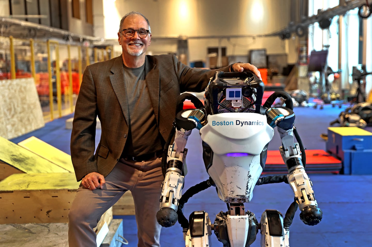 Boston Dynamics CEO Robert Playter and one of his company's Atlas robots, in 2022