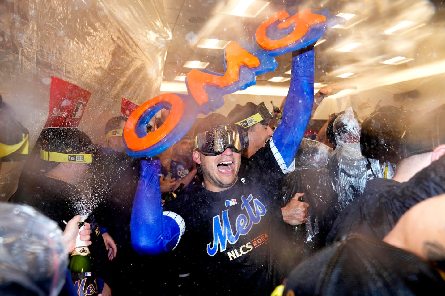 The New York Mets celebrated in the locker room after defeating the Philadelphia Phillies in Game 4 of the National League Division Series on Oct. 9 in New York.