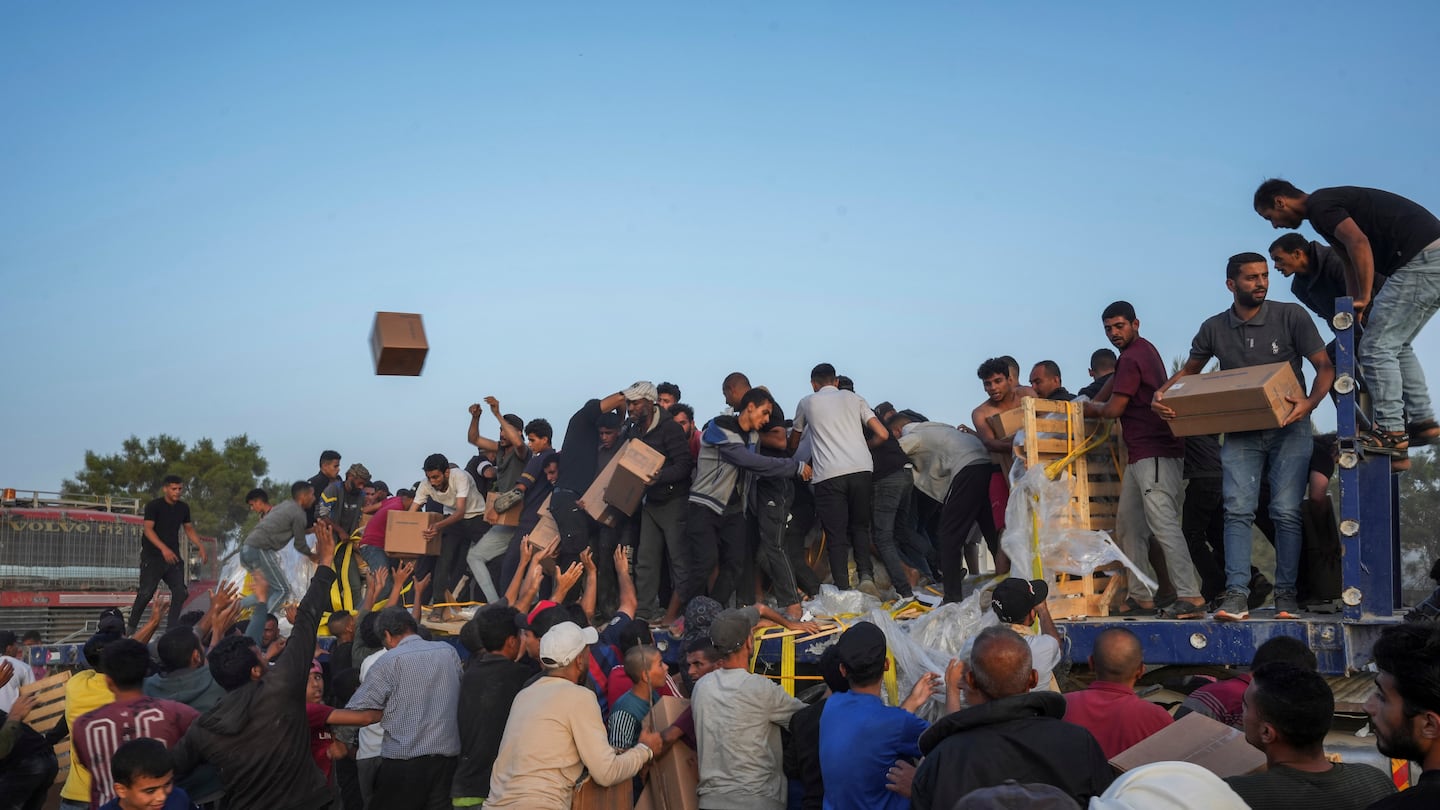 Palestinians are storming trucks loaded with humanitarian aid brought in through a new US-built pier, in the central Gaza Strip, on May 18.