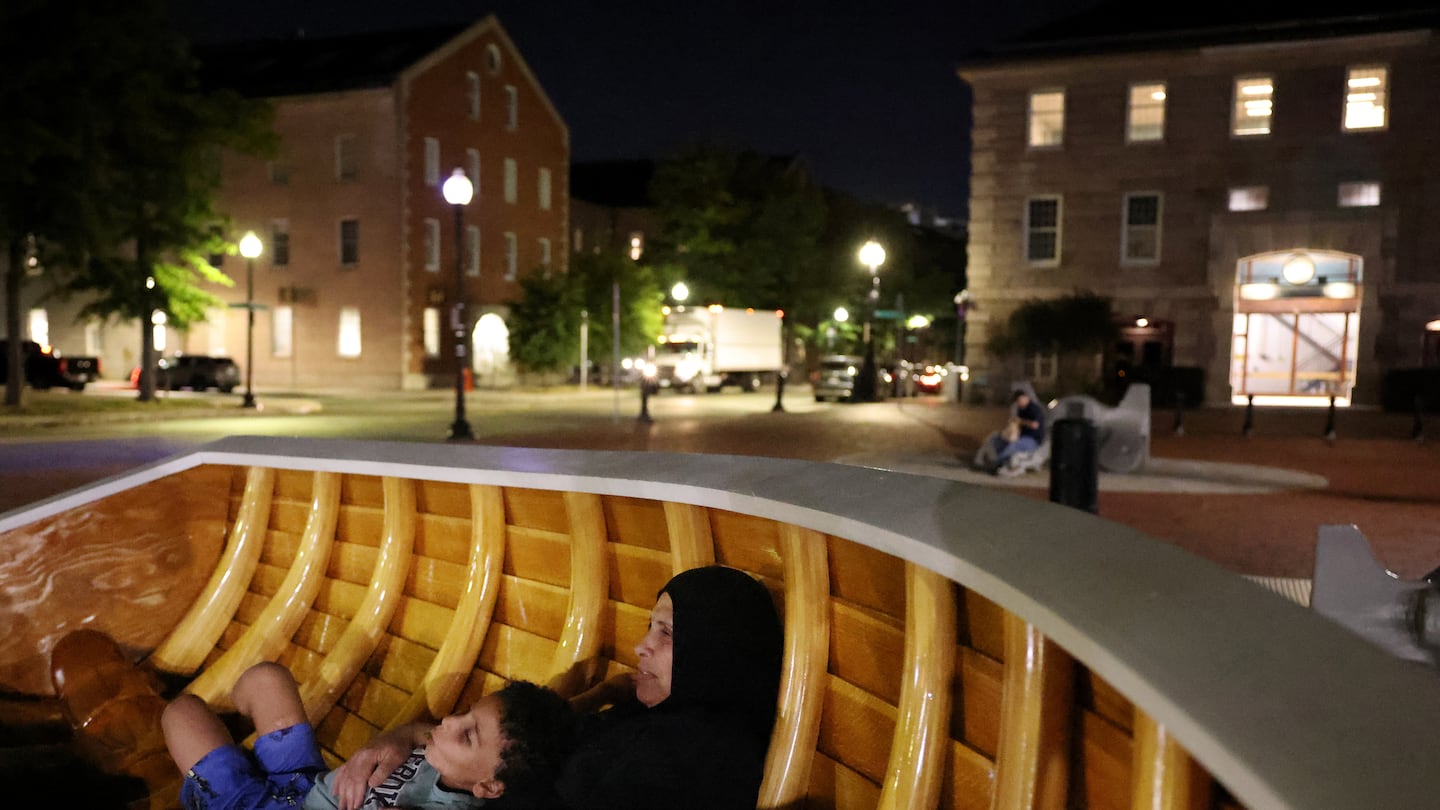 Amira Abumuhaisen held onto her grandson Aser as the two sat in a sculpture along the waterfront in Boston.