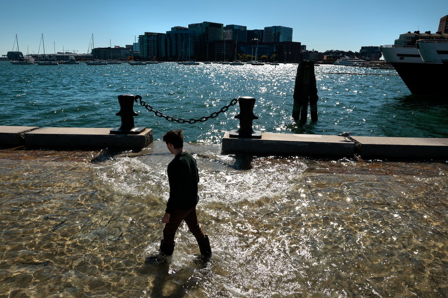 Make Pope wades through the floodwater while taking in the scene during high tide at Long Wharf in Boston on Friday.