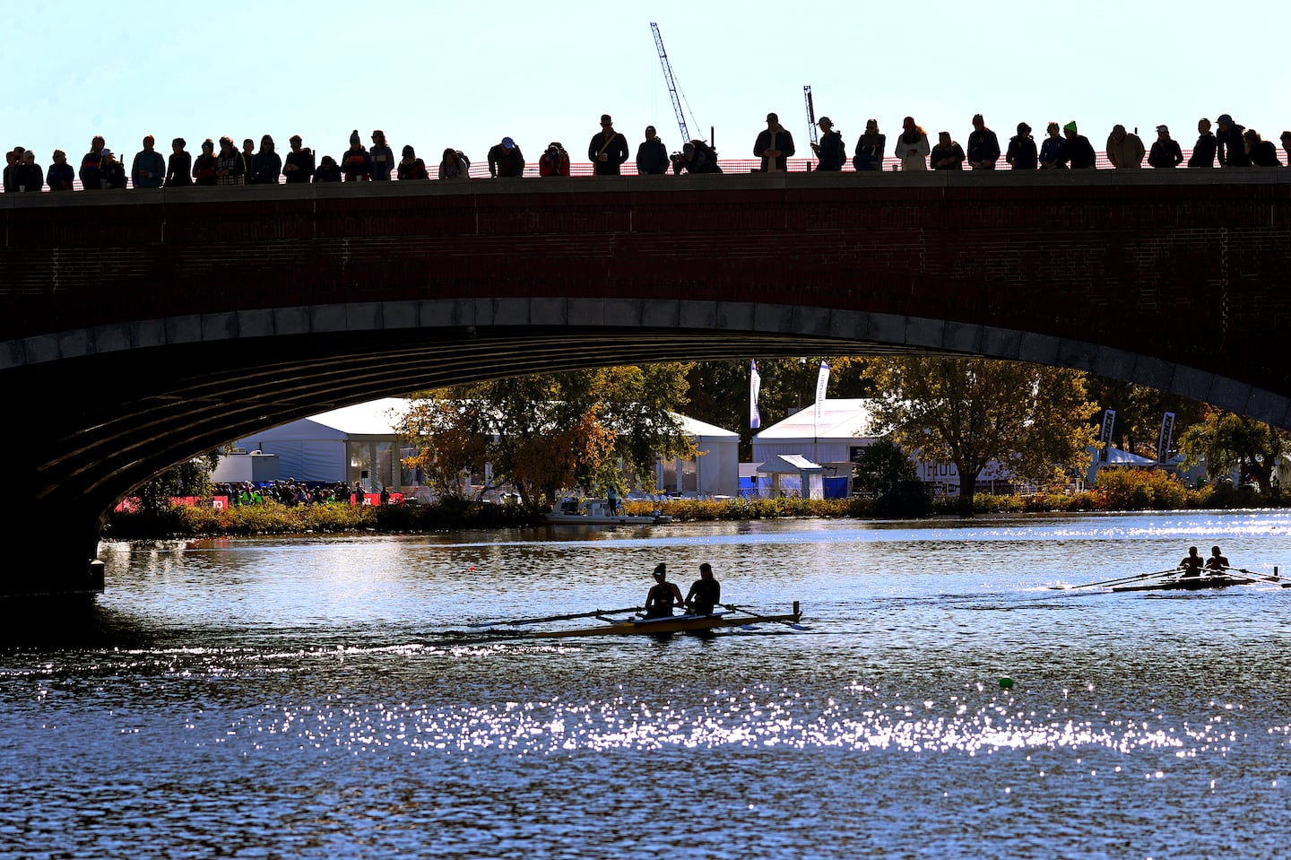 Spectators standing on the Eliot Bridge in Cambridge watched rowers below on Day 1 of the 2024 event.