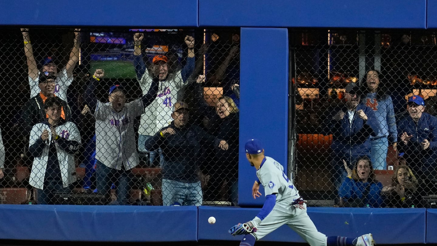 Mookie Betts scrambles to corral Jesse Winker's wall-ball single in the eighth inning of Game 5 at Citi Field, part of a final run in the Mets' big victory.