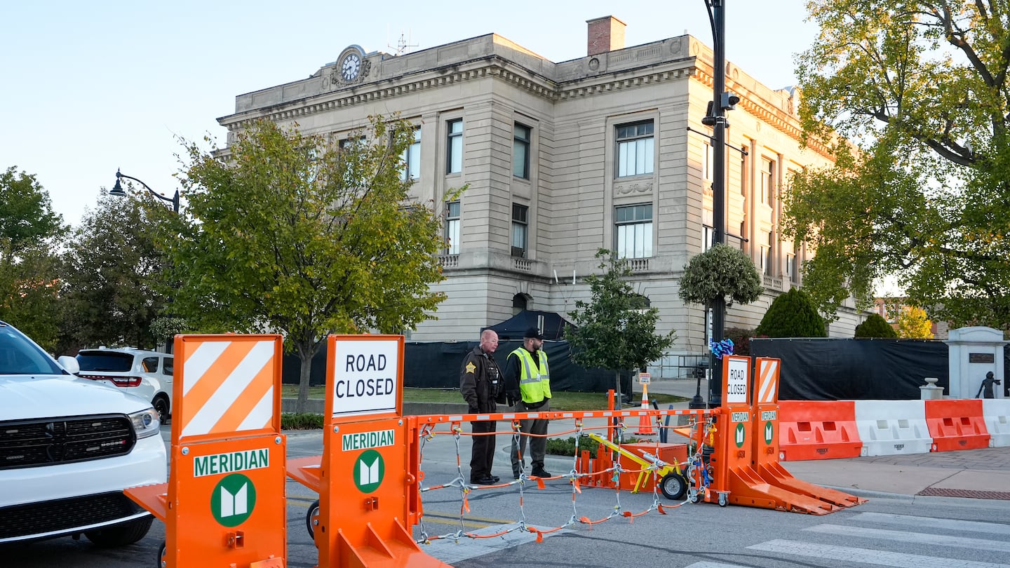 Security officers stand by a gate outside the Carroll County Courthouse where the trial of Richard Allen, accused of the slayings of two teenage girls in 2017, began Friday, Oct. 18, 2024 in Delphi, Ind.