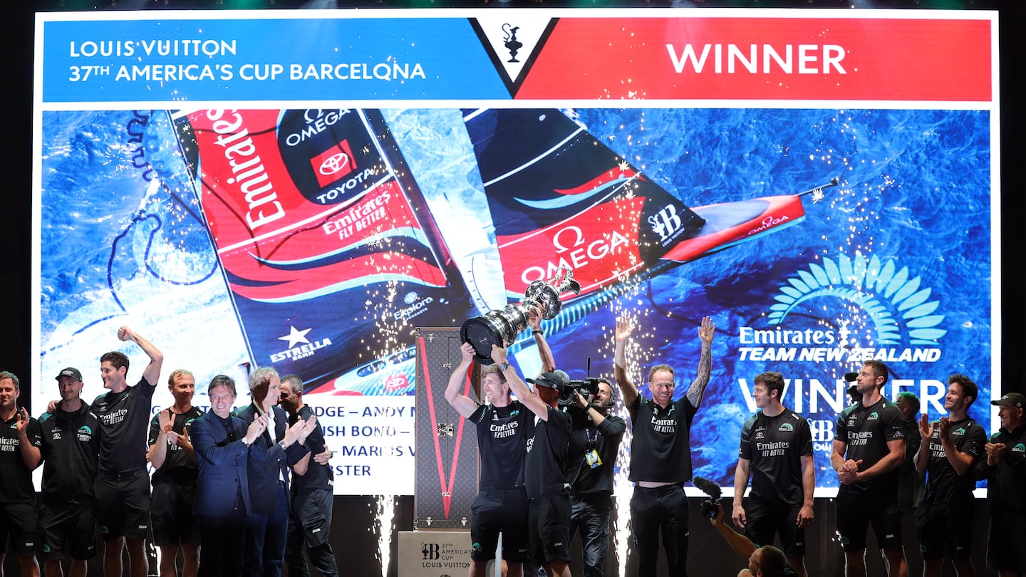 Defender Emirates Team New Zealand's co-skipper and helmsman Peter Burling raises the America's Cup on Saturday in Barcelona.