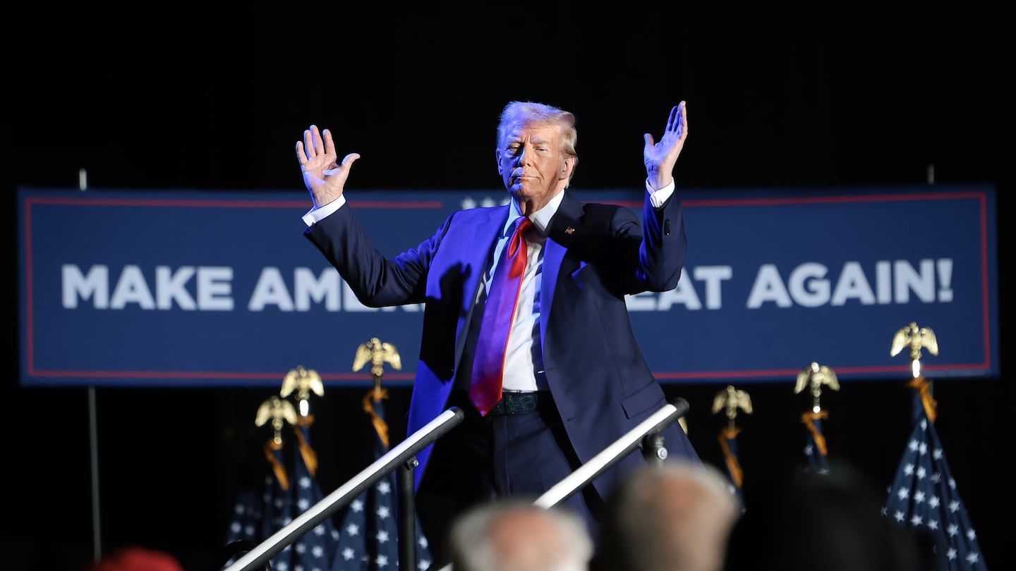 Republican presidential nominee, former U.S. President Donald Trump, reacts after his microphone malfunctioned during a campaign rally on October 18, 2024, in Detroit, Michigan.