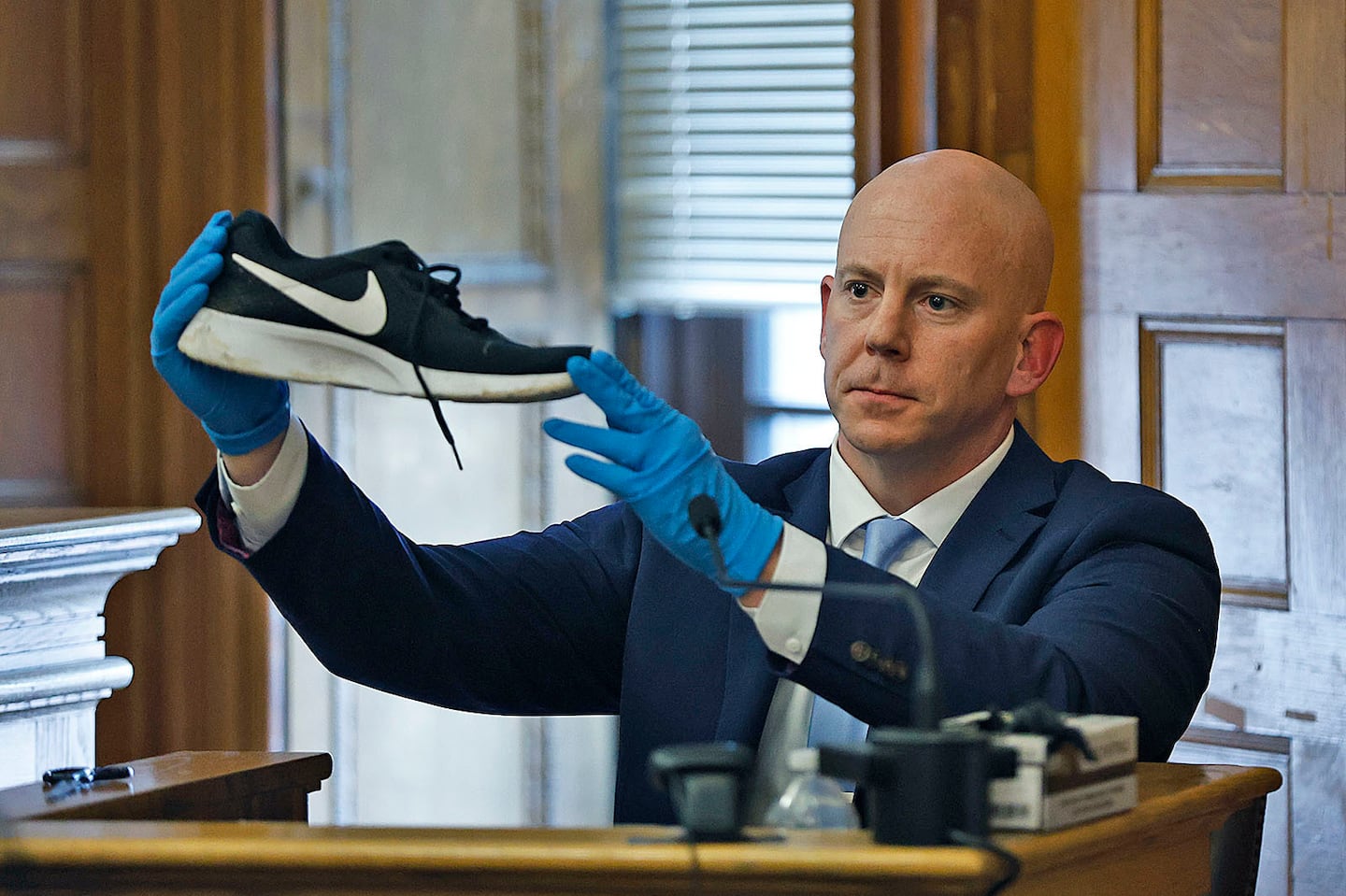 Massachusetts State Police Detective Lt. Brian Tully on the witness stand in the Karen Read murder trial in June. He is showing a sneaker found at Fairview Road that matches one taken off John O'Keefe's body at a hospital.