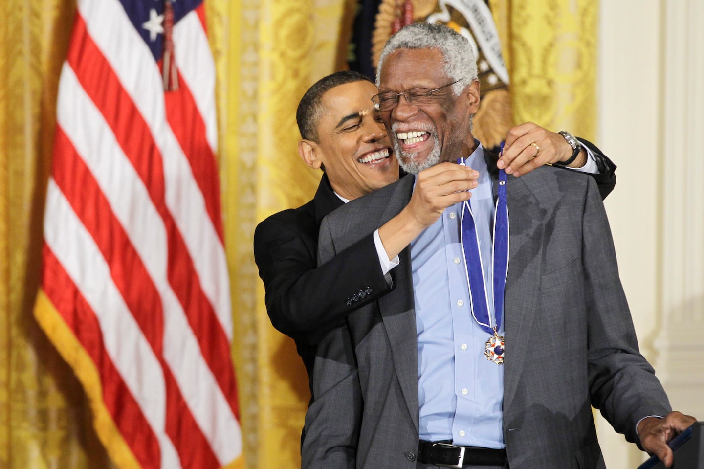 President Barack Obama (left) reaches up to present a 2010 Presidential Medal of Freedom to basketball Hall of Fame member, former Boston Celtics coach and captain Bill Russell on Feb. 15, 2011, during a ceremony in the East Room of the White House in Washington, D.C.