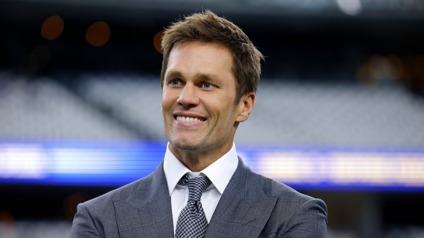 Fox Sports lead NFL analyst Tom Brady stands on the field during warmups before an NFL football game between the Detroit Lions and the Dallas Cowboys in Arlington, Texas, Sunday, Oct. 13, 2024.