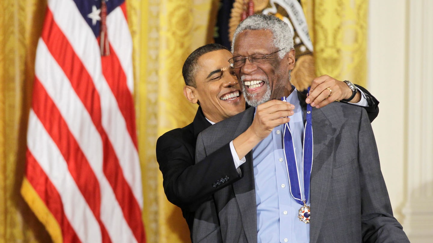 President Barack Obama (left) reaches up to present a Presidential Medal of Freedom to Bill Russell in 2011.