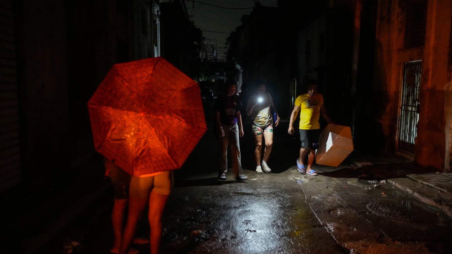 Residents walk down a street using a phone flashlight during a power outage following the failure of a major power plant in Havana, Cuba, on Oct. 19.