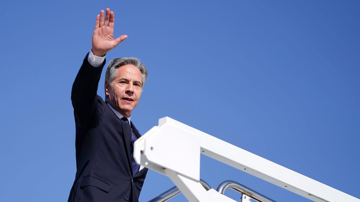 Secretary of State Antony Blinken waves as he boards a plane en route to the Middle East as he departs Joint Base Andrews, Md., on Oct. 21.