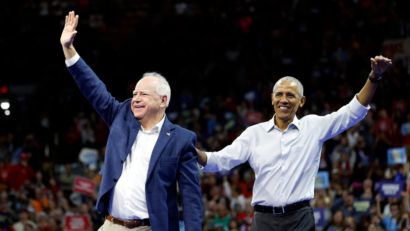 Former US President Barack Obama (right) waved next to Minnesota Governor and Democratic vice presidential candidate Tim Walz during a campaign rally in support of Vice President and Democratic presidential candidate Kamala Harris, at Alliant Center in Madison, Wisconsin, on Oct. 22.