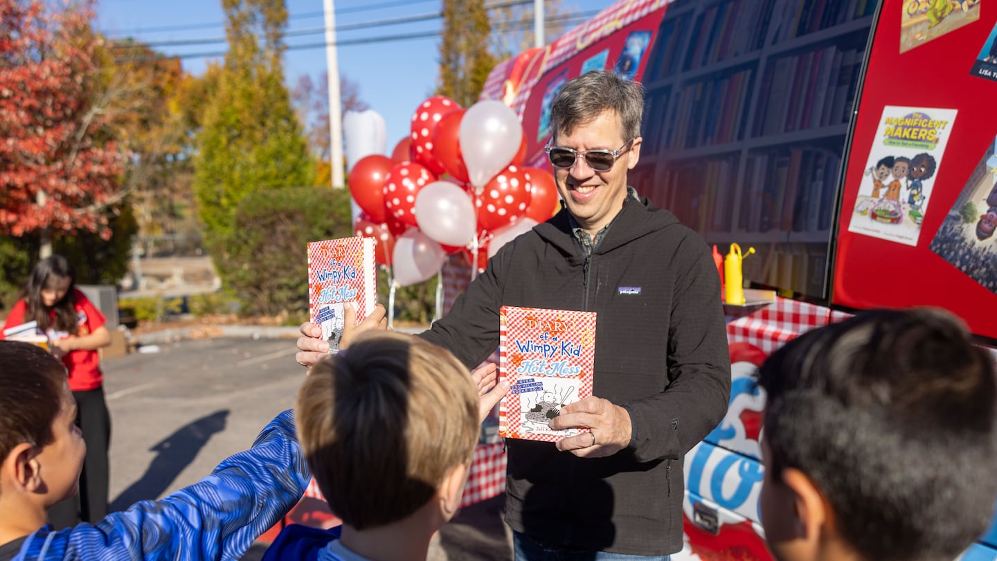 Best-selling author Jeff Kinney gave out books to kids to celebrate the launch of "Diary of a Wimpy Kid #19: Hot Mess" Sunday in Plainville.