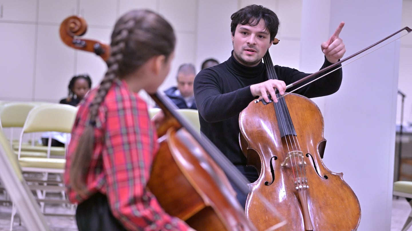 Cellist Andres Sanchez works with cello student Sofia Hernandez-Williams, 11, of Worcester, as he teaches a masterclass for young students at Symphony Hall in Boston.