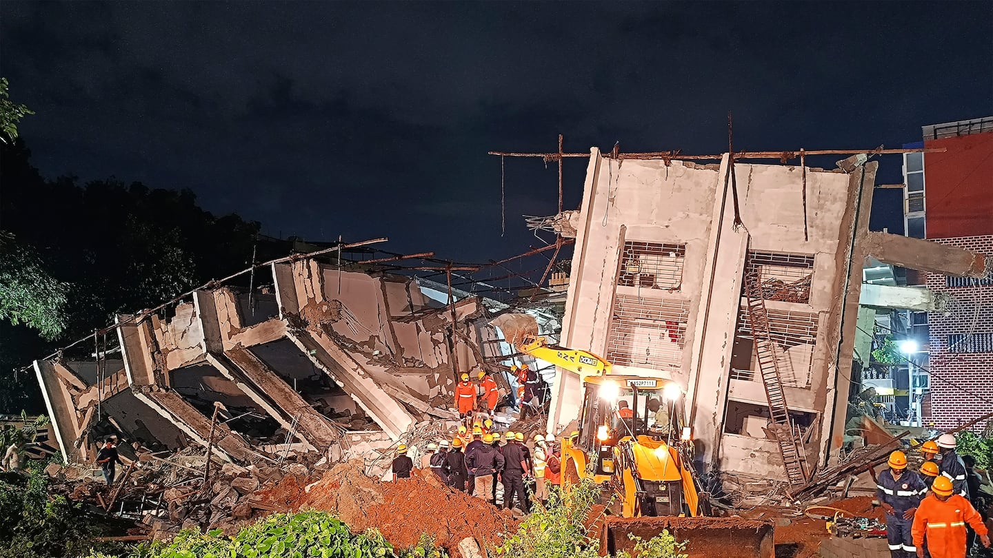 Rescue workers look for the trapped survivors under the debris of an under construction building that collapsed following heavy rains in Bengaluru, India, on Oct. 22.