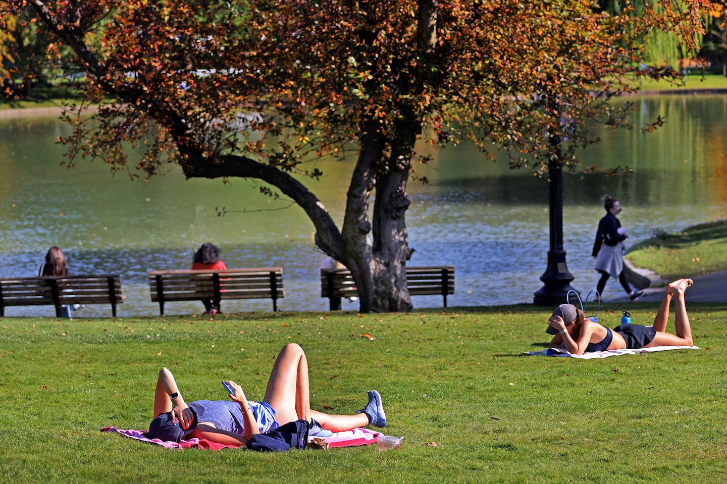 The weather has felt more like June than October in Boston lately as some people relax at the Boston Public Garden on Tuesday.