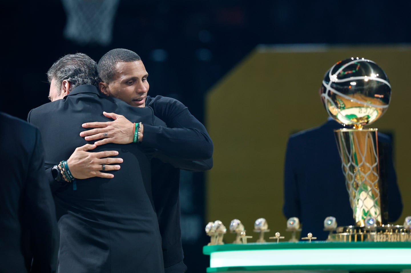 Celtics coach Joe Mazzulla and team owner Wyc Grousbeck embraced before the banner raising, with the O'Brien Trophy and the rings nearby.