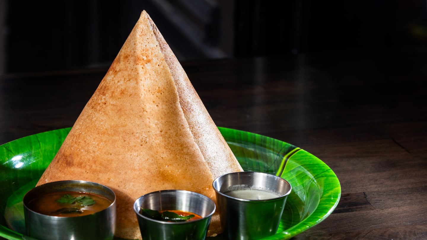 Plain dosa, a crispy crepe-like dish served in the shape of a cone, with sauces at Chennai Eats in Watertown.