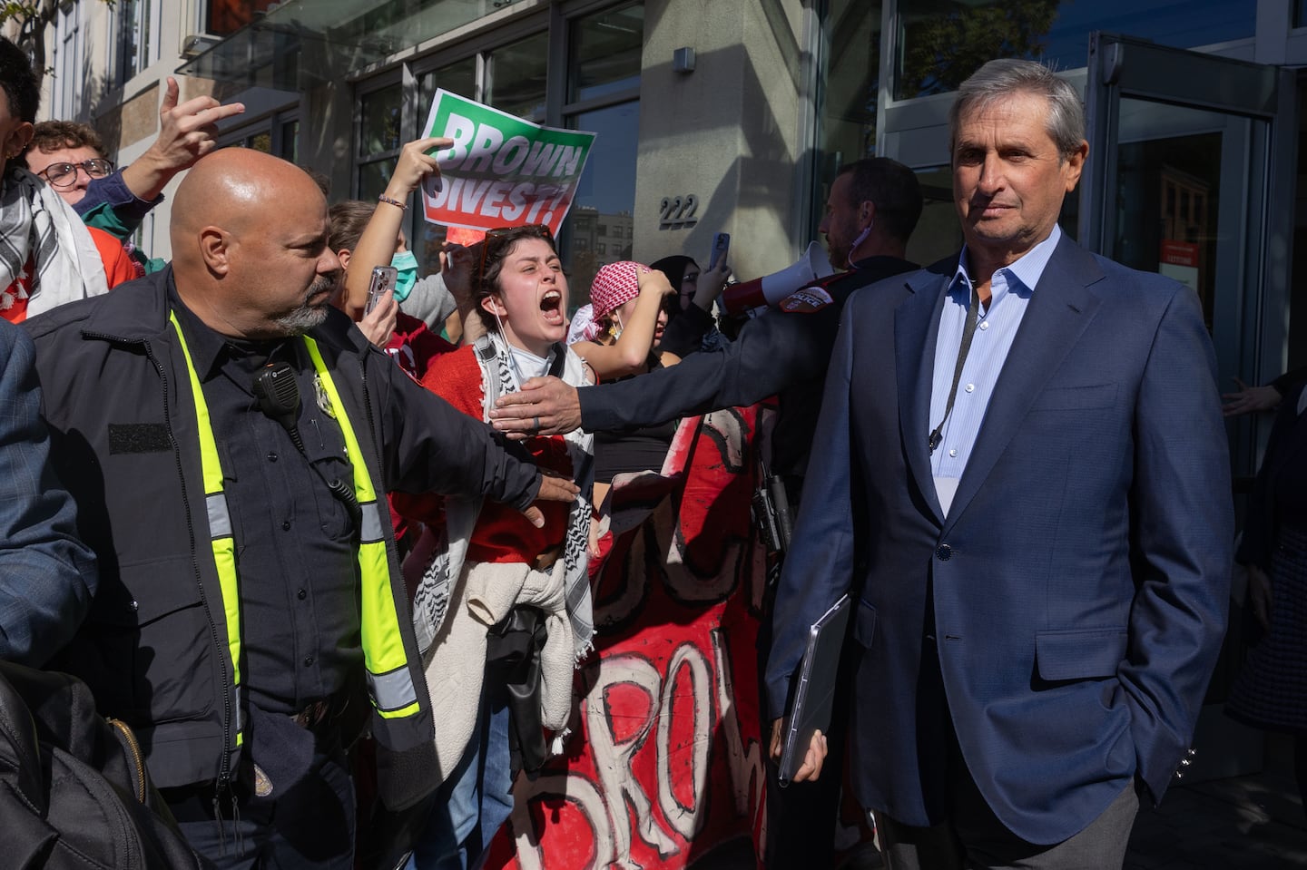 Protesters chanting "shame" surrounded the Brown University Police security corridor as Brown Corporation members exited Warren Alpert Medical School to a shuttle on Oct. 18.