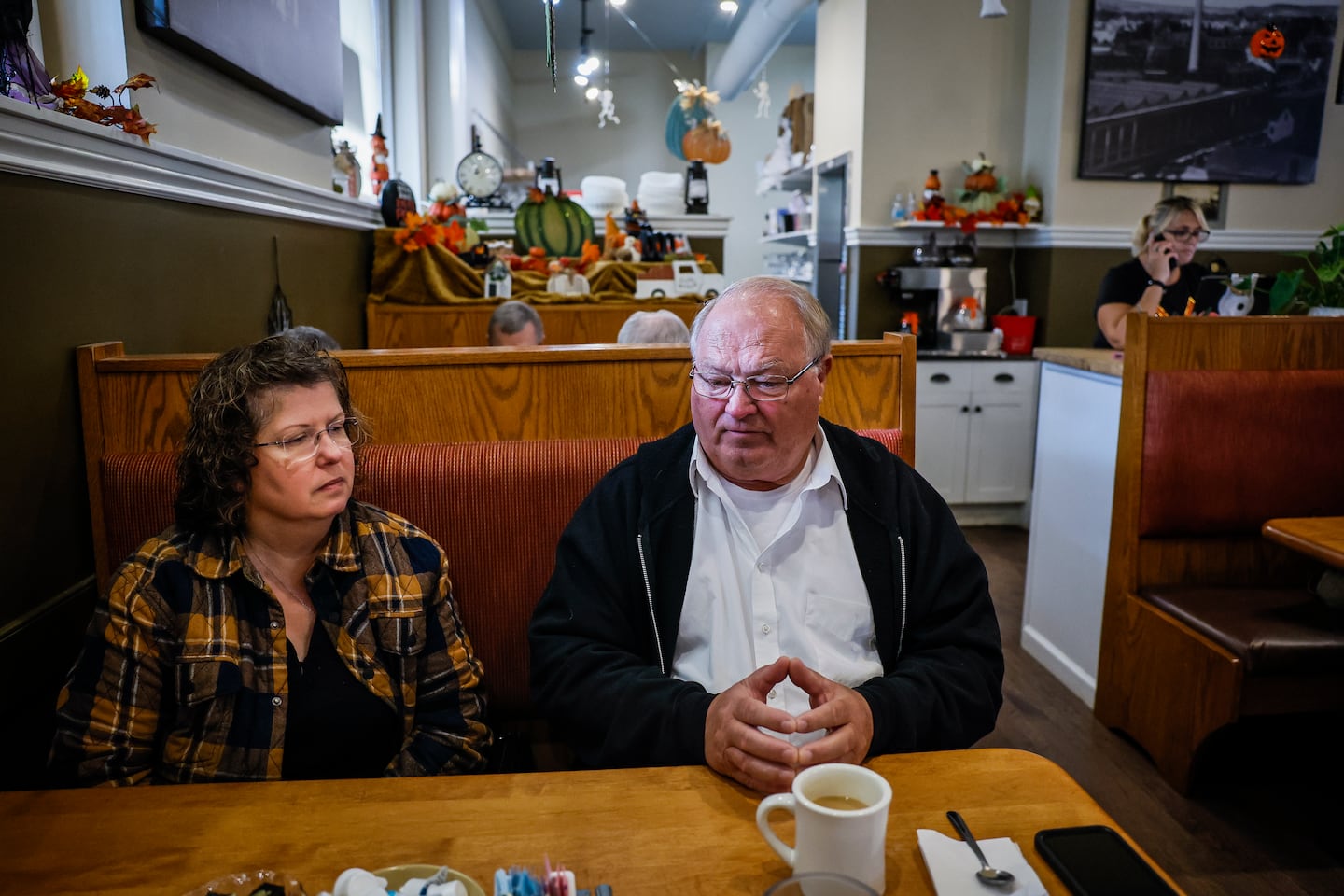 Kathy Lebel and Leroy Walker reminisced about loved ones at Station Grill restaurant in Lewiston, Maine, while Walker's daughter-in-law Tracey Walker, background, answered the phone. Tracey began working at Station Grill, which Lebel owns, after cutting down hours at her job working as bartender due to anxiety following the Oct. 25, 2023, mass shooting that claimed her husband Joseph's life. Joseph Walker was working at Schemengees Bar & Grille, then owned by Lebel, when he became one of 18 victims in the tragedy.