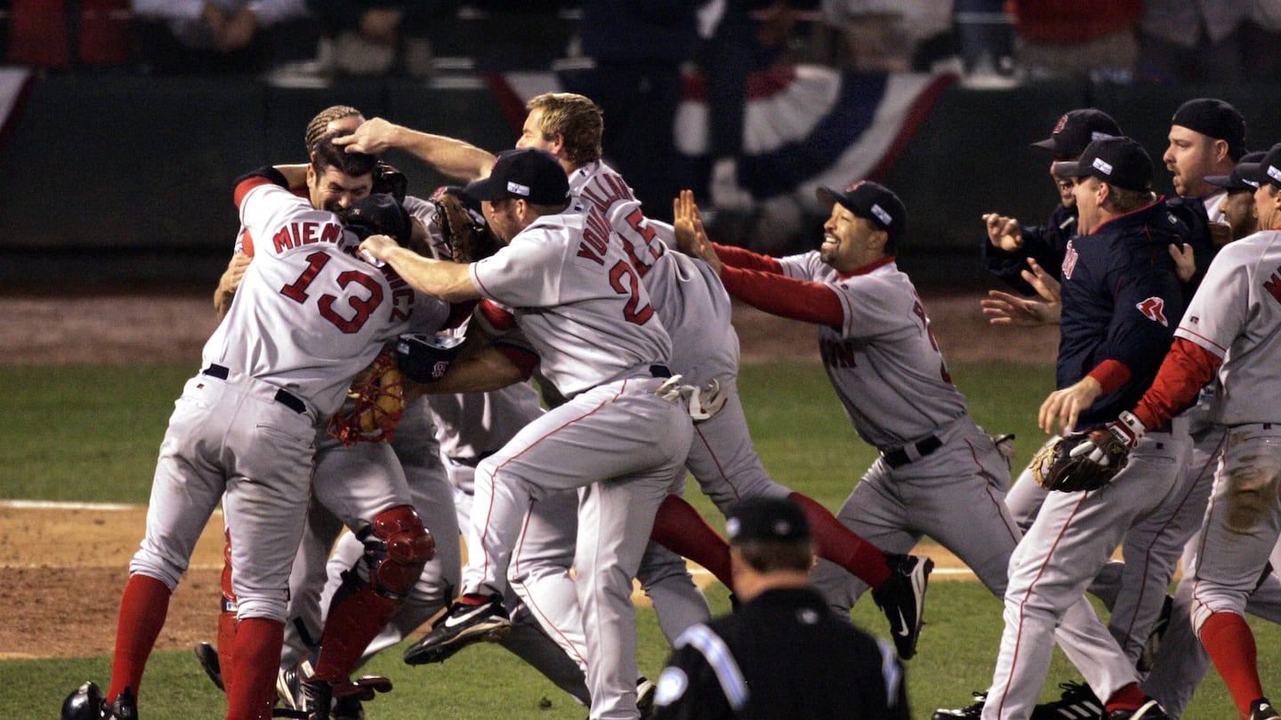 Red Sox players storm the field after winning the World Series.