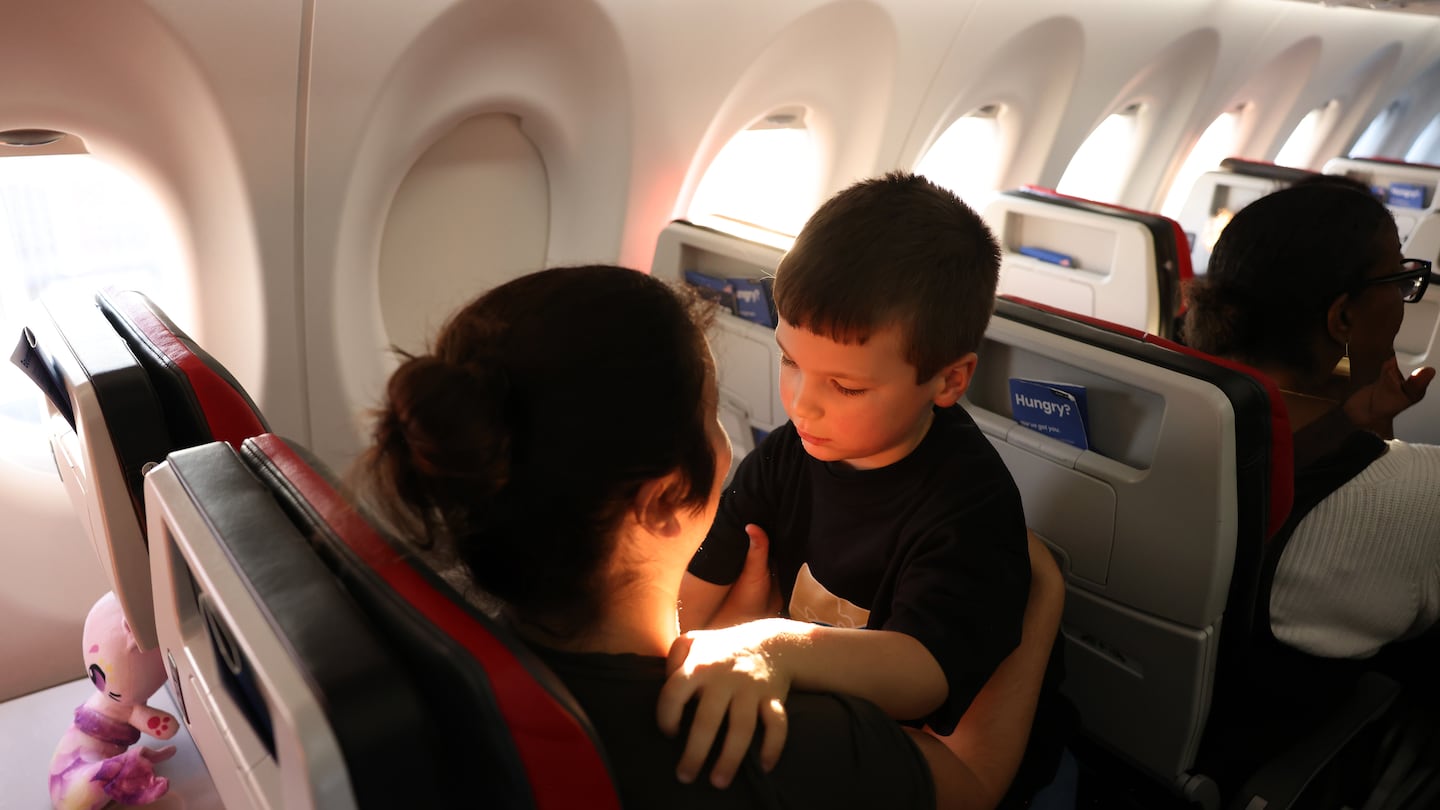 Four-year-old Xander, who is on the autism spectrum, snuggled with his mom, Natalie, as they settled into their seats during an "Autism Flies" practice airport experience hosted by Breeze Airways at Rhode Island T.F. Green International Airport.