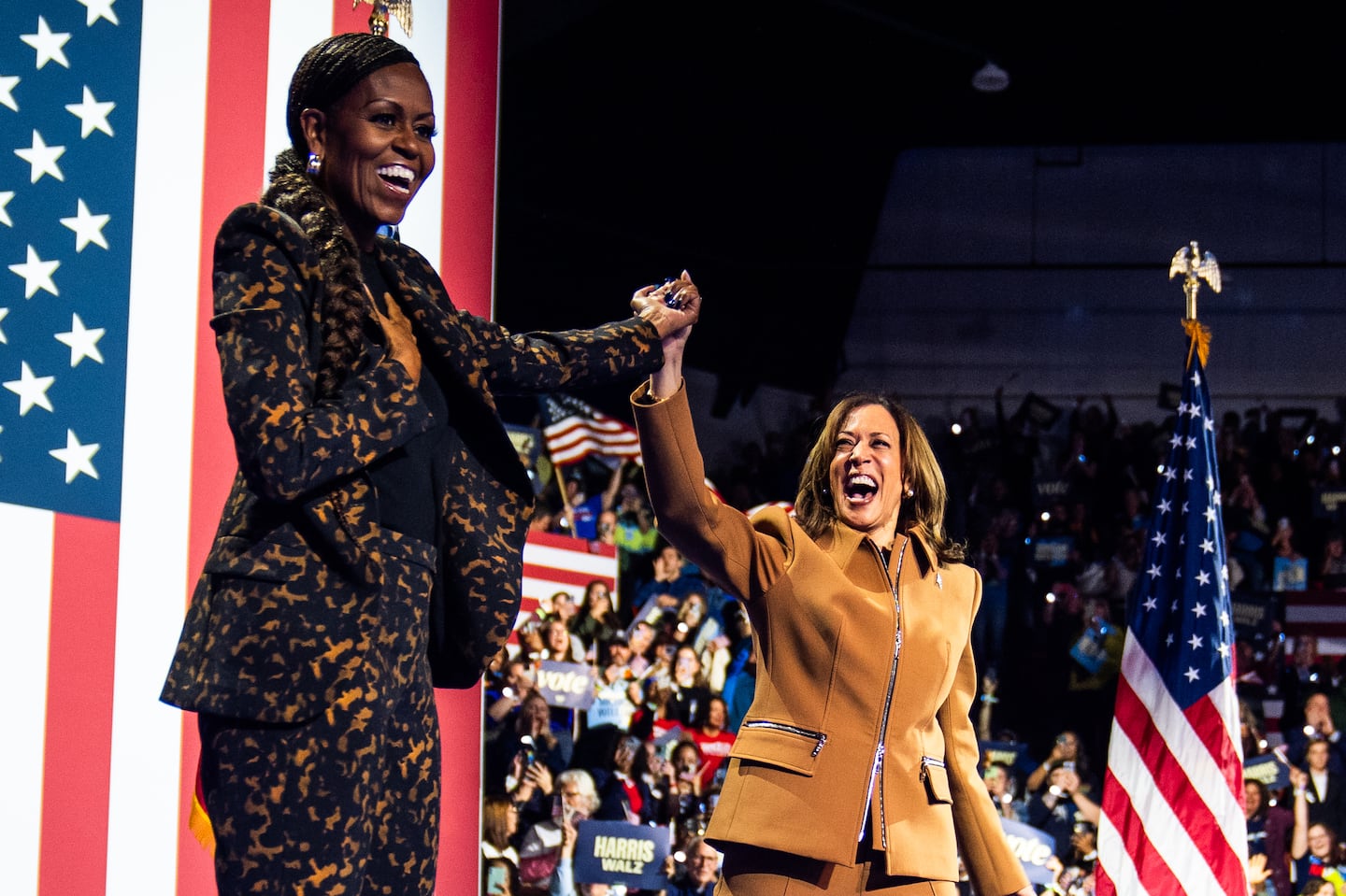 Former first lady Michelle Obama and Vice President Kamala Harris acknowledge an enthusiastic crowd in Kalamazoo, Michigan, on Saturday.