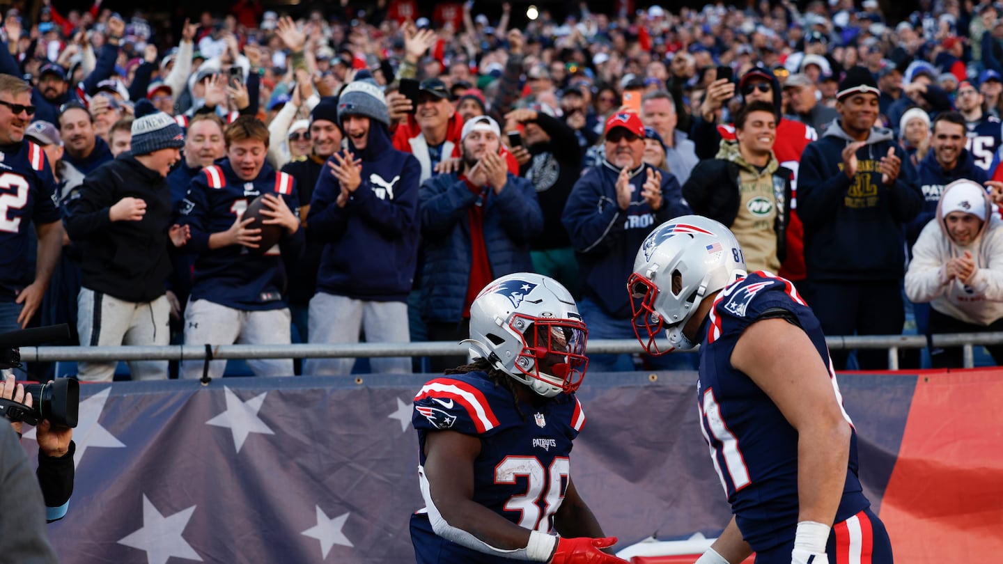 Rhamondre Stevenson and Austin Hooper celebrate after a 2-point conversion late in the fourth quarter.