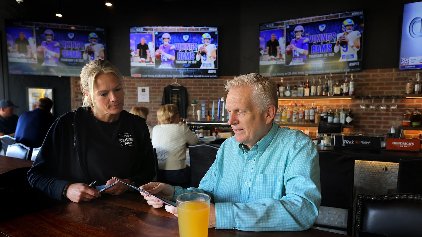 At The Common Room in Needham, bartender Jennifer Gorman takes a lunch order from Glenn Mulno, founder and moderator of the steadfastly positive Needham Restaurants group on Facebook.