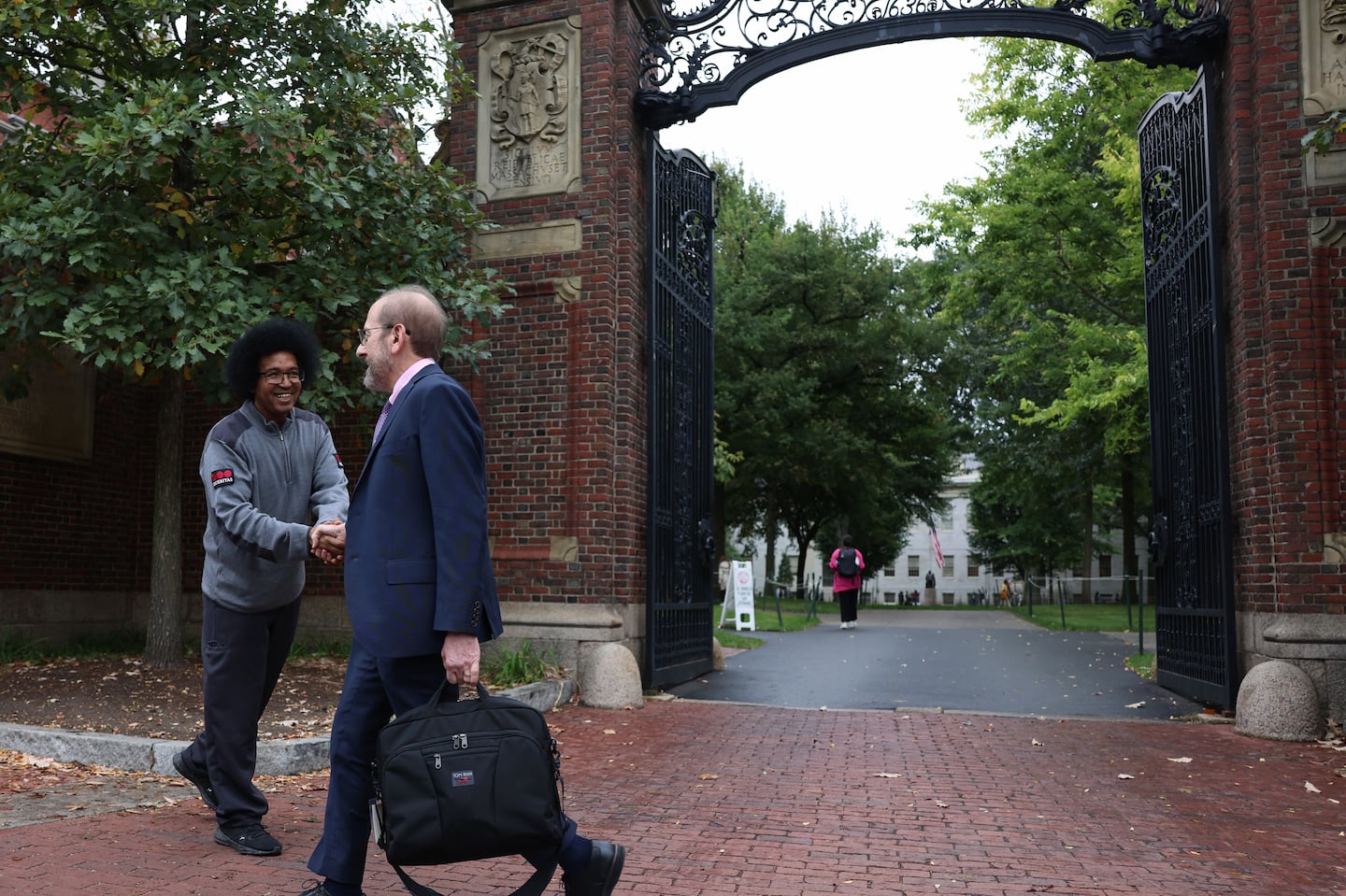 In September, Harvard University President Alan Garber shook hands with a security guard as he walked past Johnston Gate.