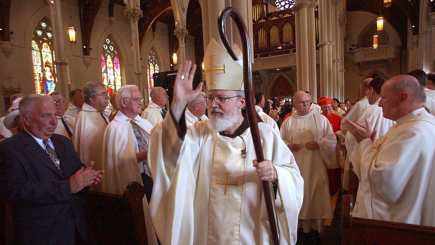 Archbishop Sean O'Malley blessing his guests while he walked through Holy Cross Cathedral at the end of a ceremony.