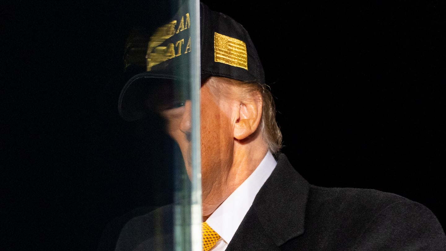 Donald Trump is reflected in bullet resistant glass before he speaks during a campaign rally in Traverse City, Mich, on Oct. 26.