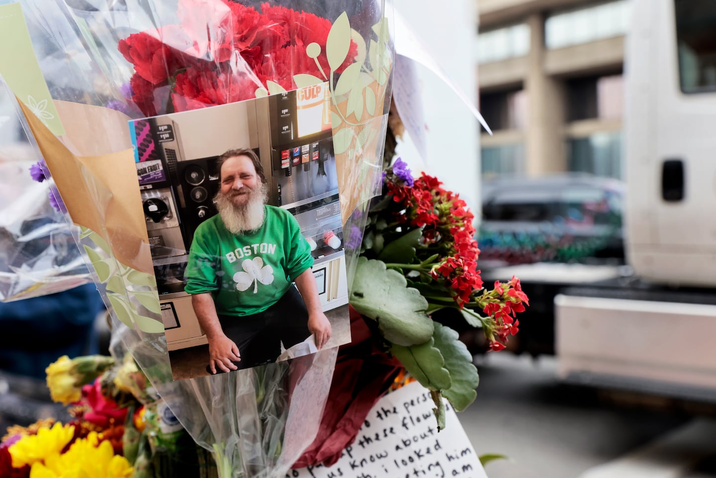 Flowers, cards, and photos were added to a memorial post during a remembrance for Glenn Durkee.